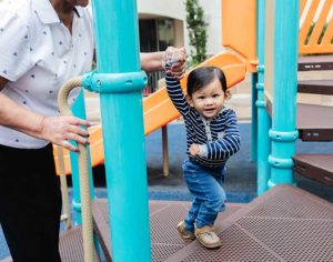 small boy with adult playing on the playground